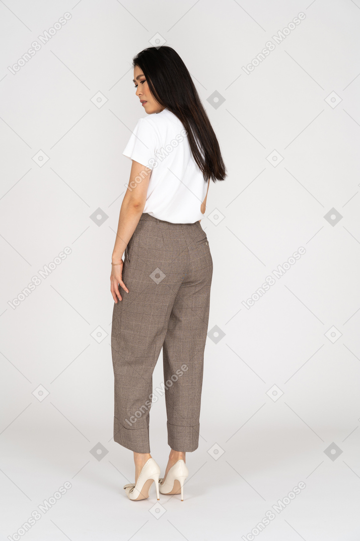 Back view of a young naughty woman in breeches turning away