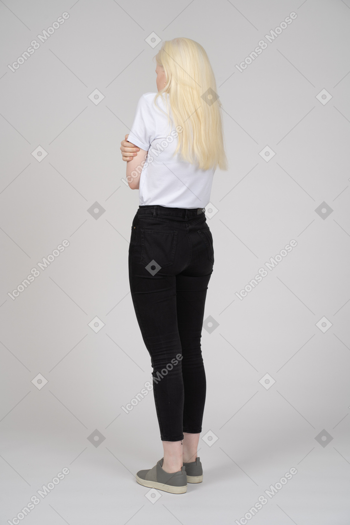 Rear view of a young blonde girl freezing