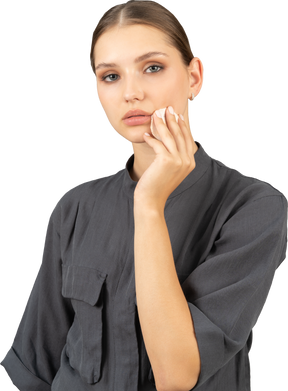 Трехчетвертный вид молодой женщины в комбинезоне, снимающей макияж