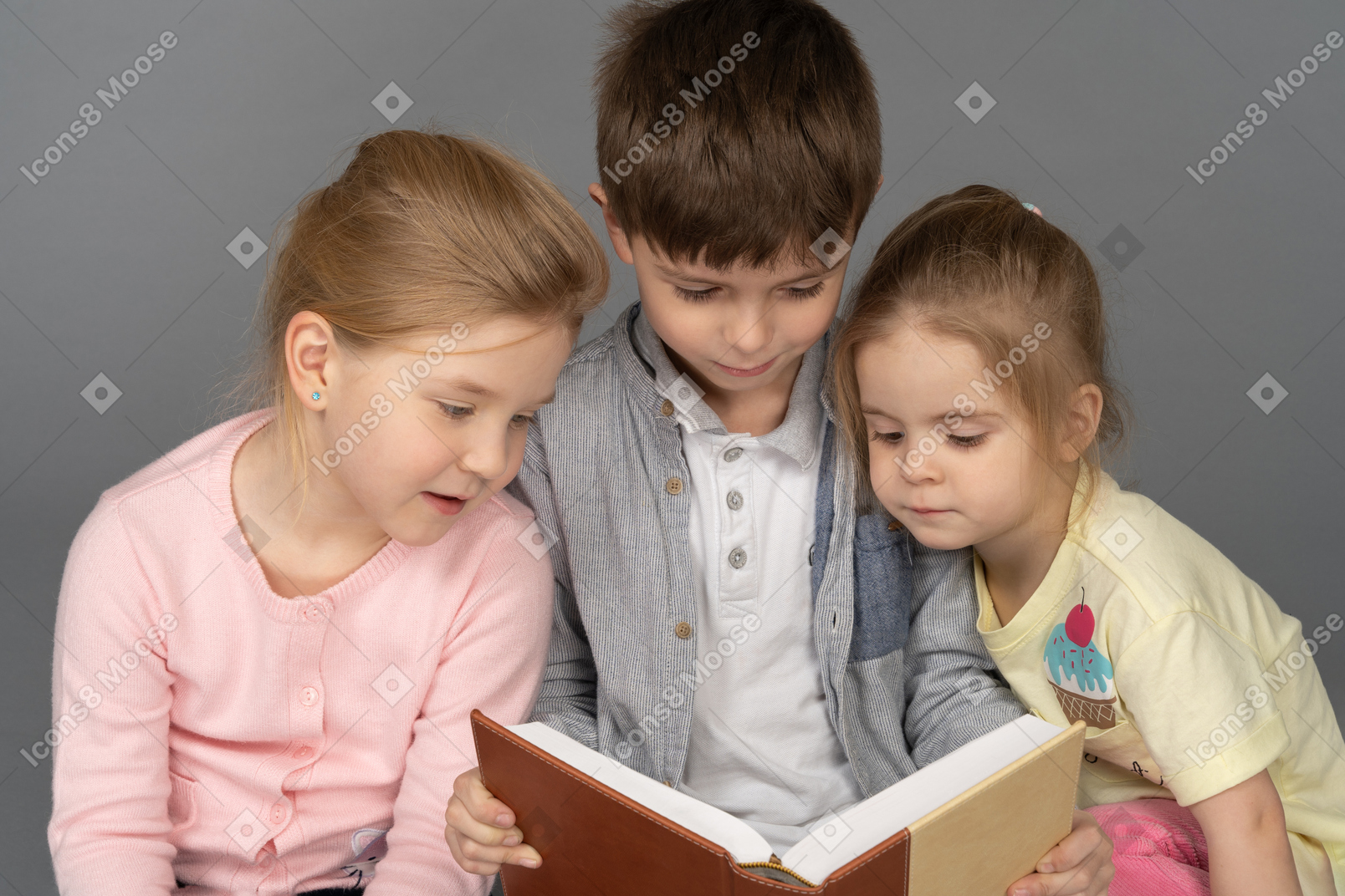 Tre adorabili bambini che leggono baldoria