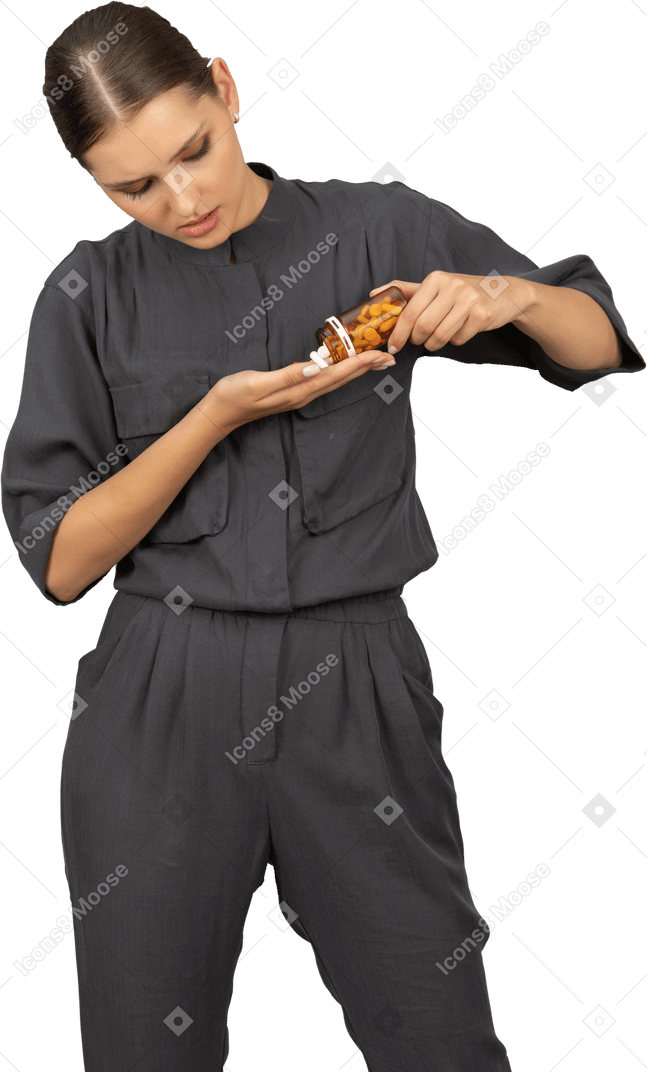 Front view of a young woman in a jumpsuit pouring the pills out of a jar