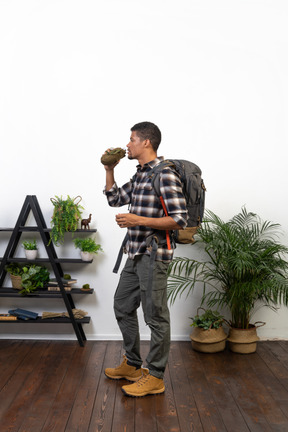 Side view of a backpacker holding a flask