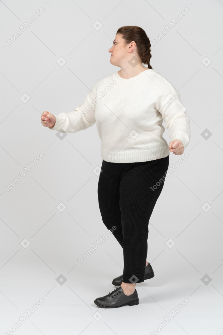Femme dodue dans des vêtements décontractés dansant