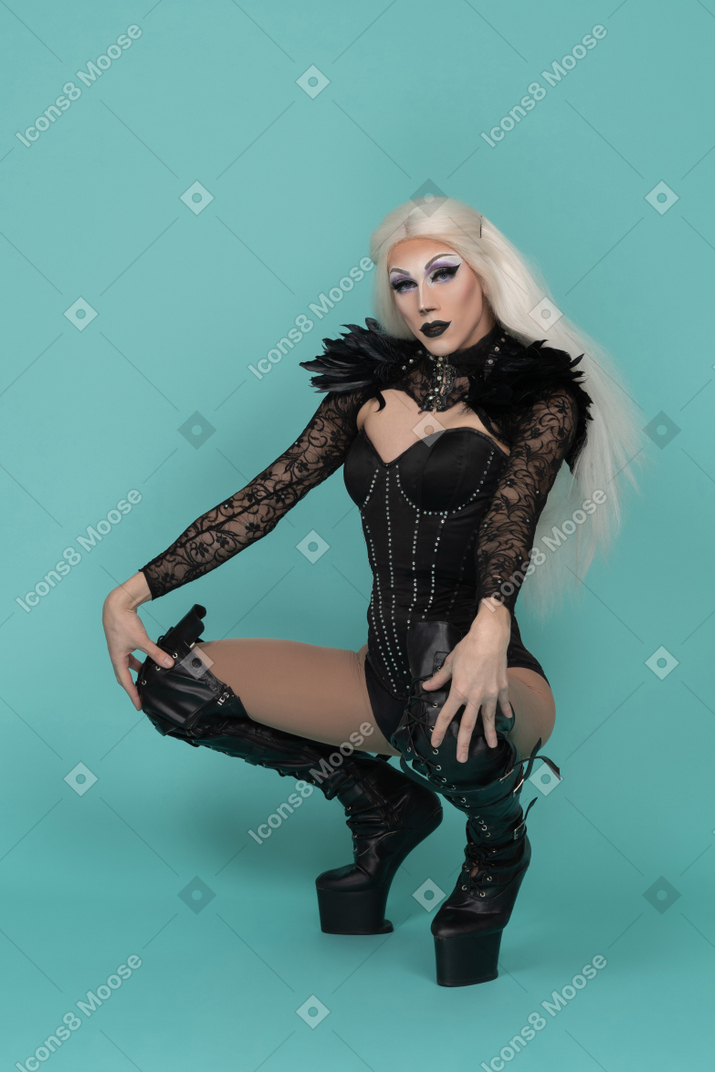 Drag queen squatted down looking at camera