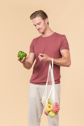 Young guy holding a string bag with groceries