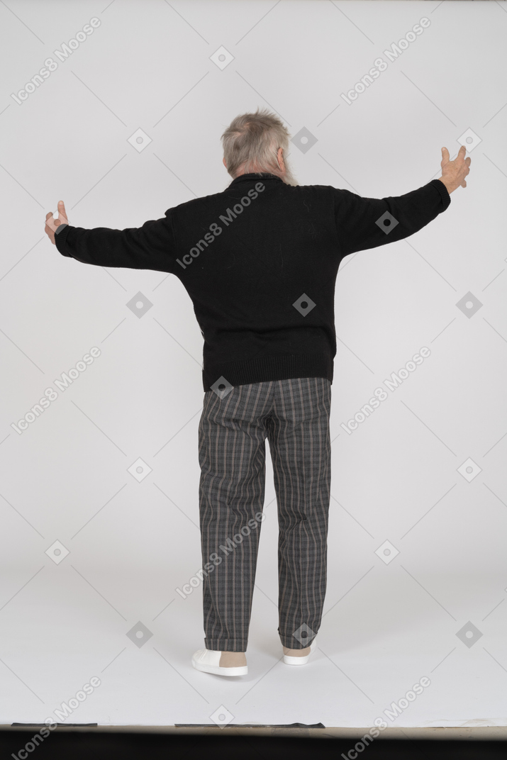 Rear view of old man showing something large with hands