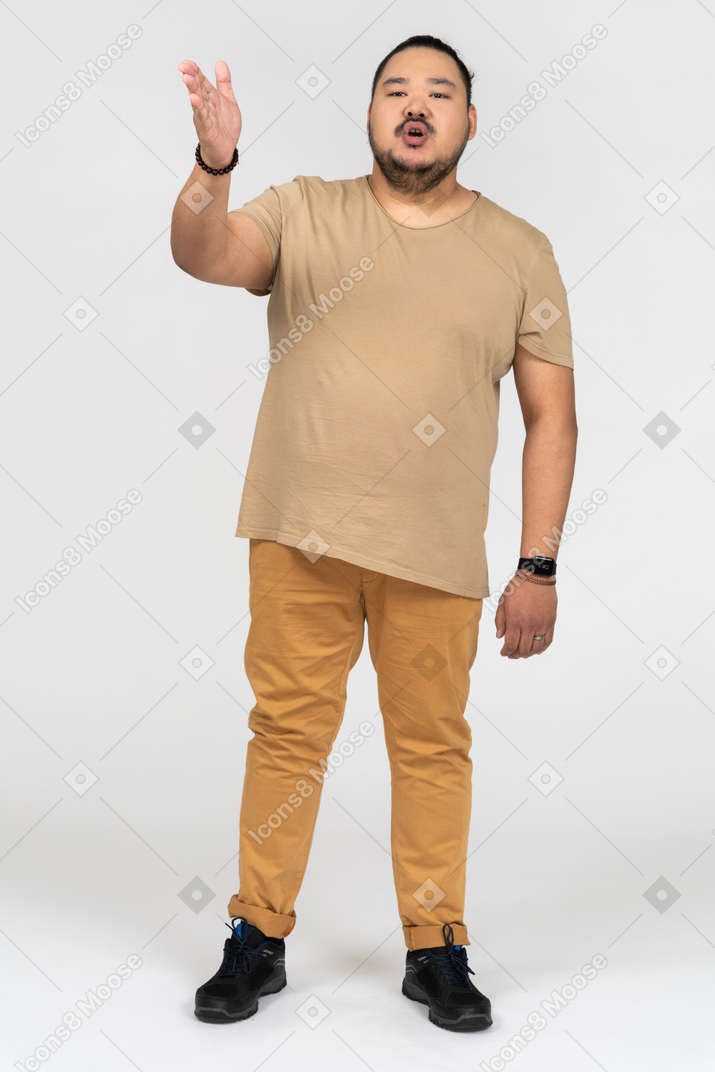 Young asian man gesturing sideways to camera