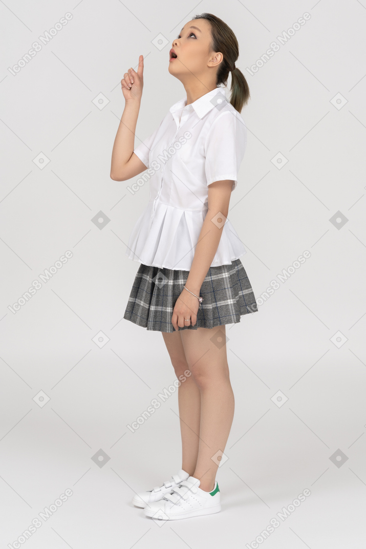A surprised asian girl pointing upwards