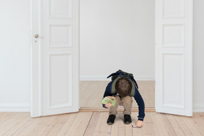 Little boy picking something up from the floor