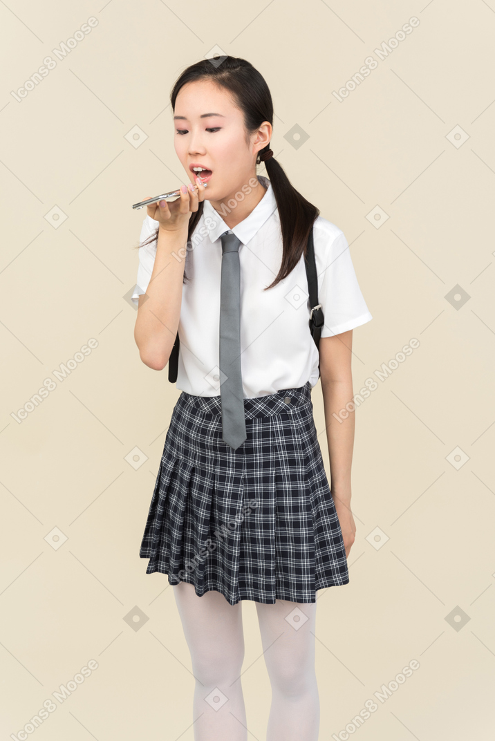 Asian school girl recording a voice message