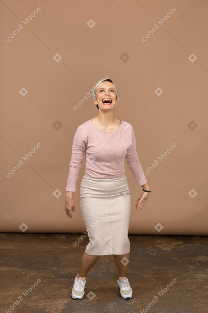 一个穿着休闲服的快乐女人蹲着抬头仰望的前视图