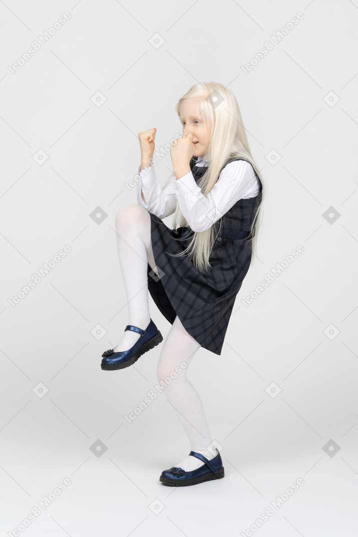 Schoolgirl putting fists up while celebrating