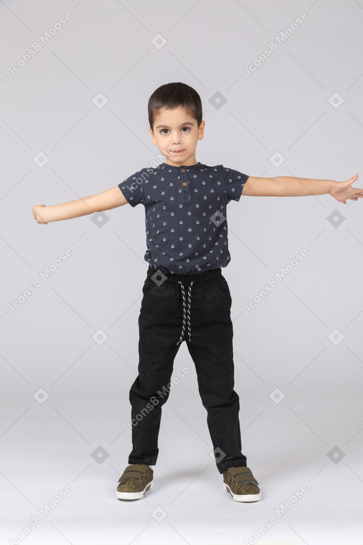 Vista frontale di un ragazzo carino in posa con le braccia tese