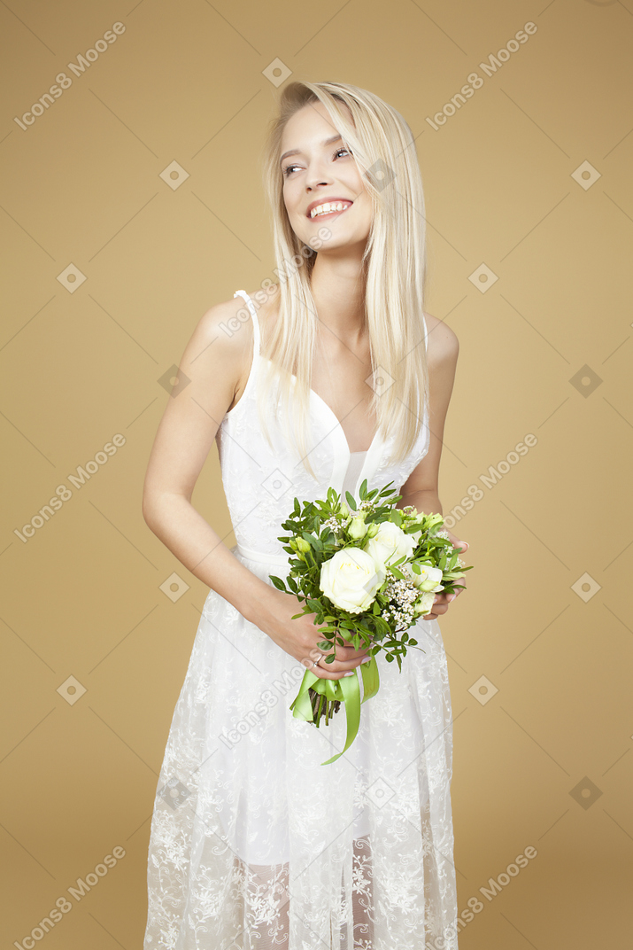 Beautiful bride holding bouquet and posing for a photo