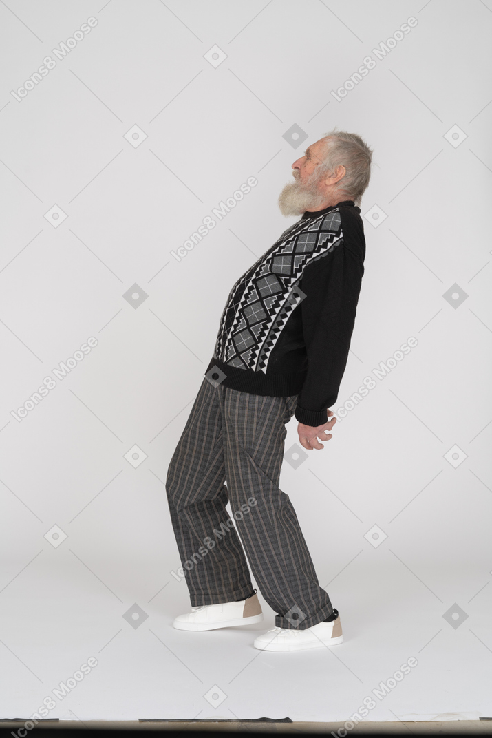 Elderly man standing and bending back