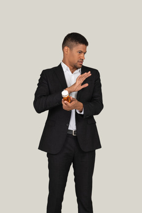 Disgusted african american man holding pills bottle