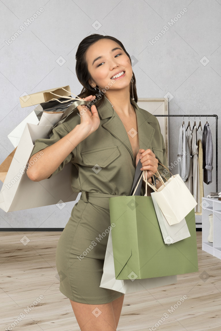 Mujer joven caminando con bolsas de compras