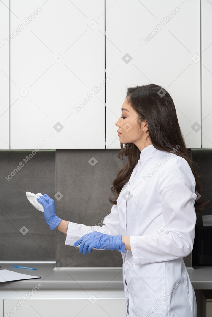 Side view of a female doctor cleaning her medical cabinet