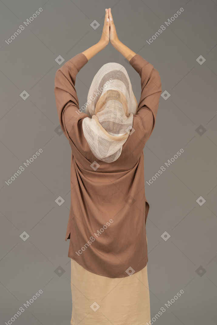 祈る手を上げる女性