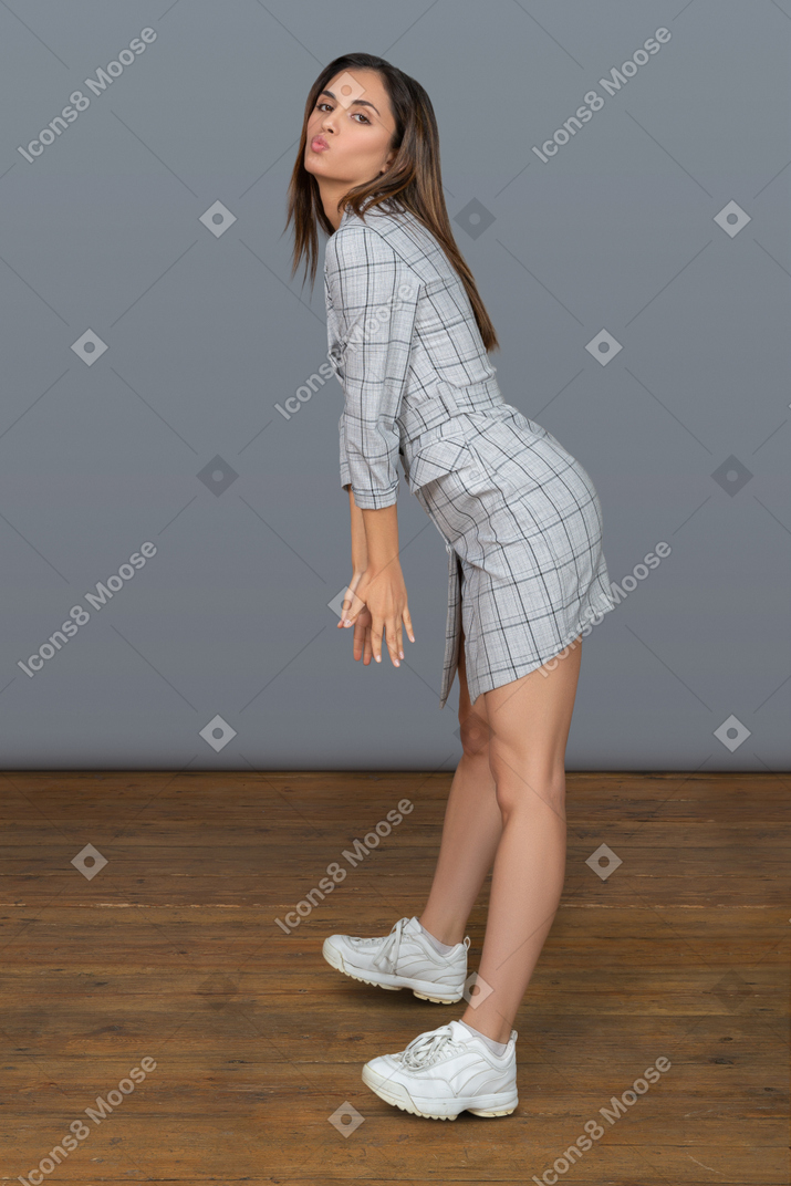 Giovane donna attraente che si piega in avanti mentre posando