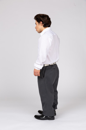 ビジネス カジュアルな服装の若い男の 4 分の 3 背面図