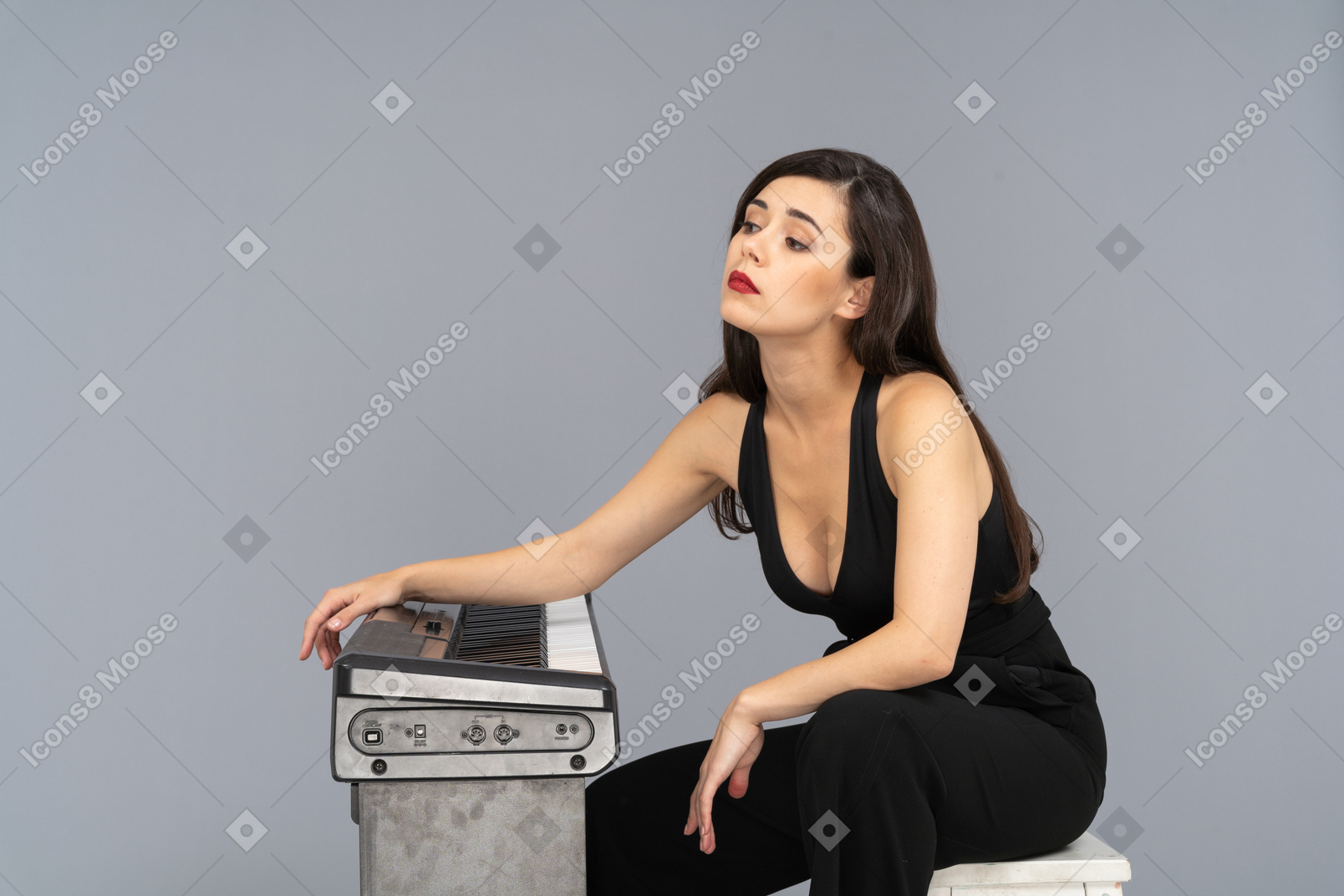 ピアノのそばに座っている疲れた若い女性の側面図