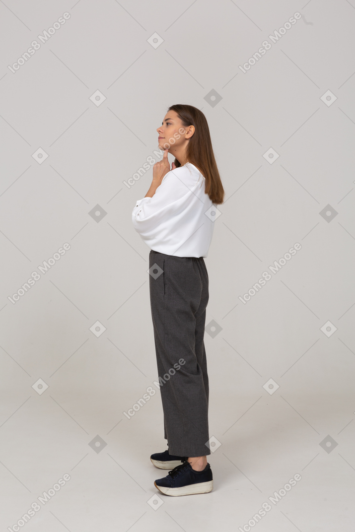 Side view of a thoughtful young lady in office clothing touching chin
