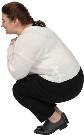 Vista lateral de uma mulher gorda com roupas casuais agachada