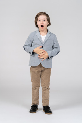 A boy with his mouth open and hands on his stomach