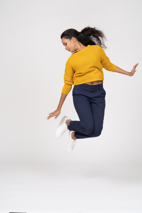 一个穿着休闲服跳跃的女孩的前视图