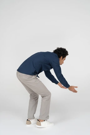 Side view of a man in casual clothes bending down
