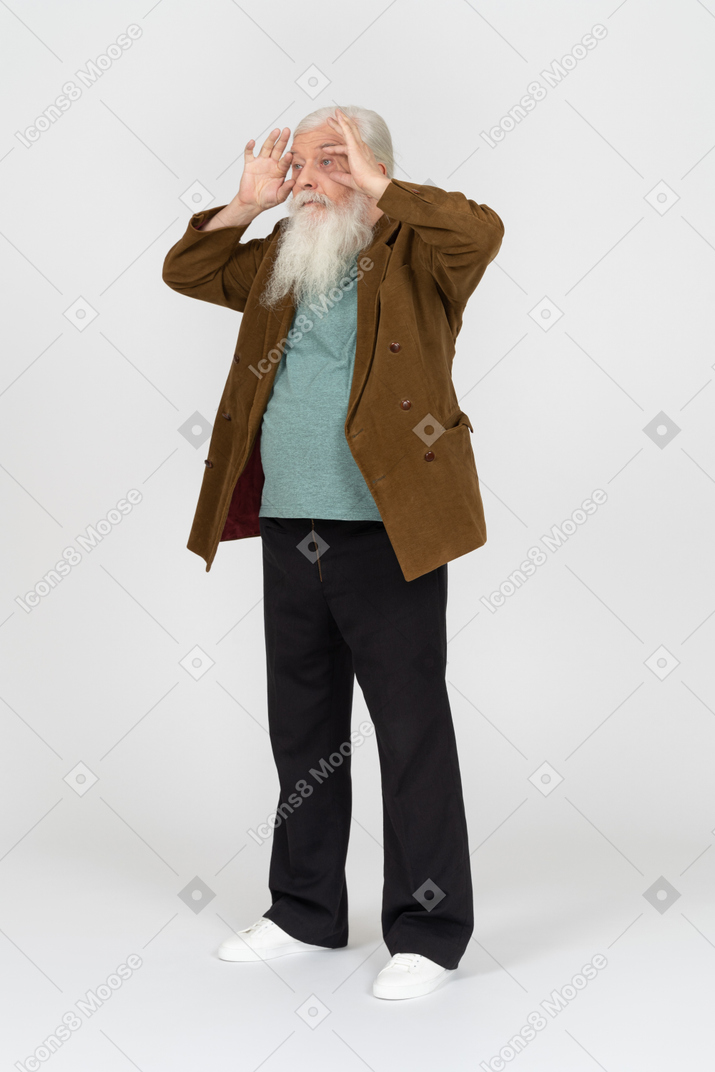 Old man forcing his eyes open with hands