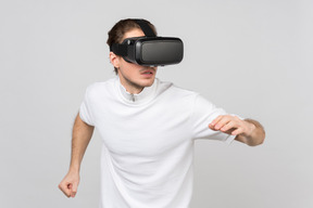 Young man moving carefully somewhere in virtual reality