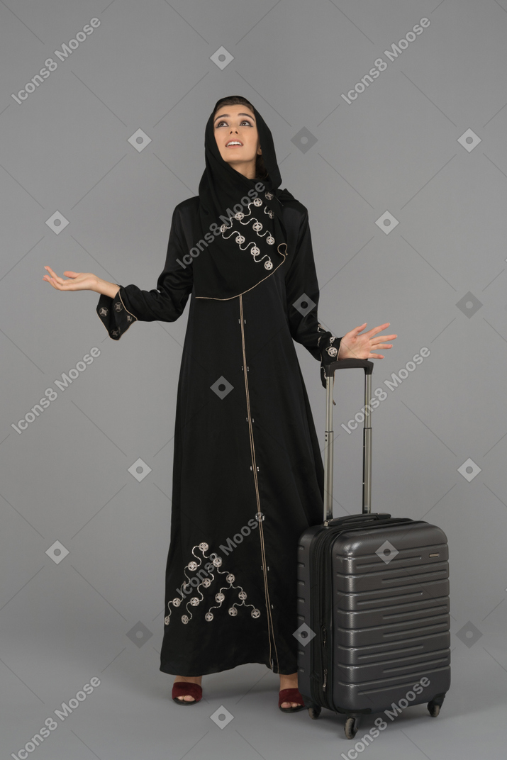 Una donna musulmana coperta che alza le mani sgomento