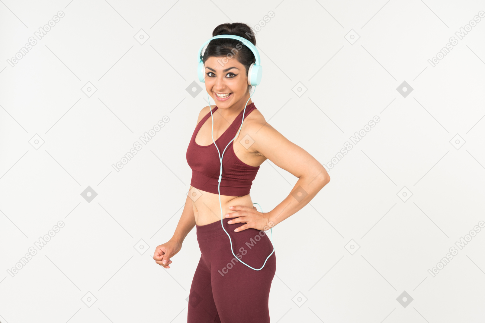 Cheerful young indian woman listening to music in headphones