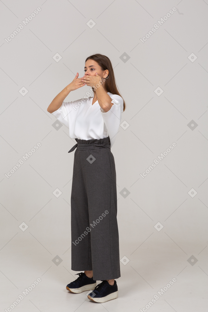 Three-quarter view of a young lady in office clothing hiding her mouth