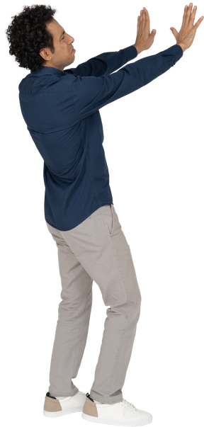 Vista lateral de um homem com roupas casuais mostrando um gesto de pare