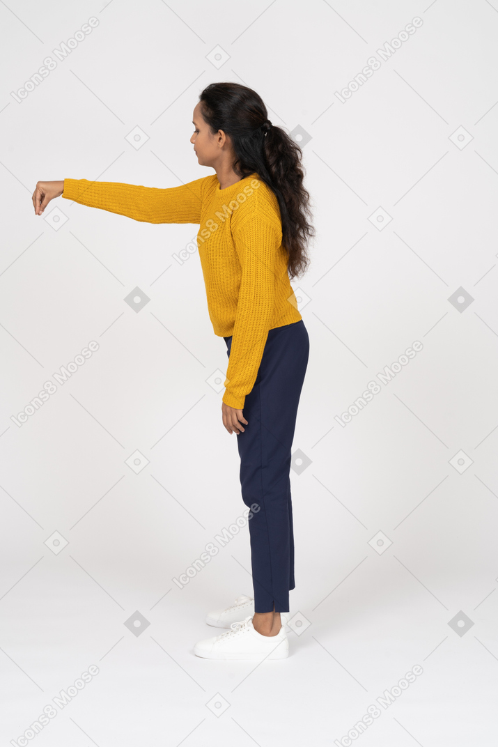 Side view of a girl in casual clothes pointing down