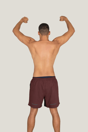 A back side view of the strong sunburnt man showing his biceps