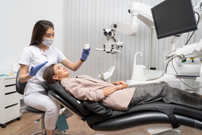 Full-length of a female dentist and her female patient looking at teeth model