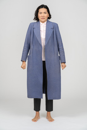 Donna sconvolta in un cappotto in piedi con i pugni chiusi