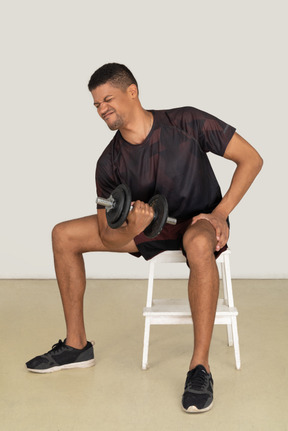 Young man in sports clothes lifting weights