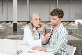 Médecin utilisant un stéthoscope sur un patient