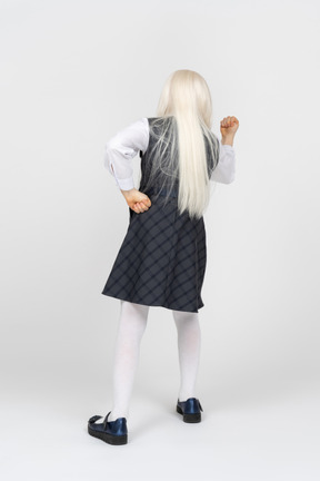 Back view of a schoolgirl shaking her fist