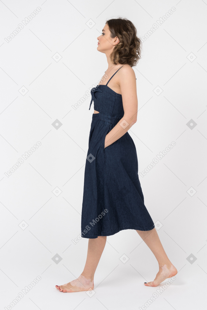 Девушка без сапог, держащая руки в карманах при ходьбе вбок