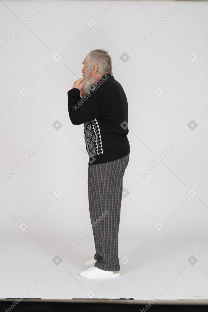 Side view of old man with fingers in mouth