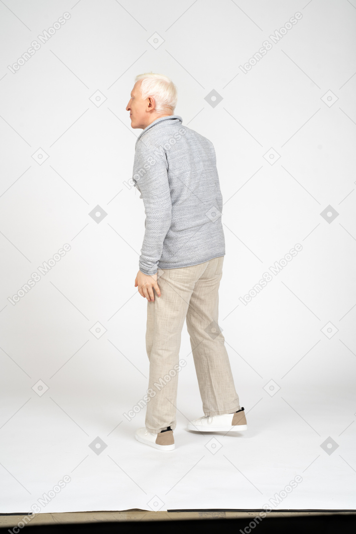 Back view of a blonde man standing sideways