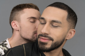 Close-up of a young man kissing his boyfriend