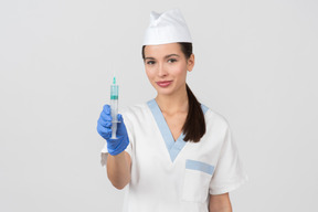 Attractive nurse demonstrating a disposable syringe