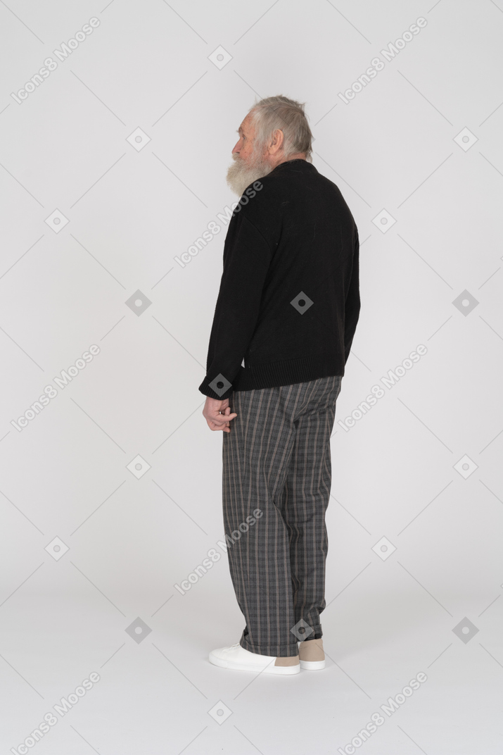 Three-quarter back view of an elderly man standing